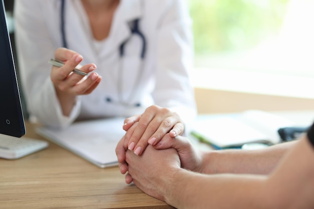 Female doctor in white medical uniform consulting male patient in hospital woman therapist