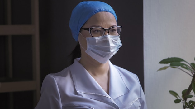 Dottoressa in white uniform in piedi nel suo ufficio