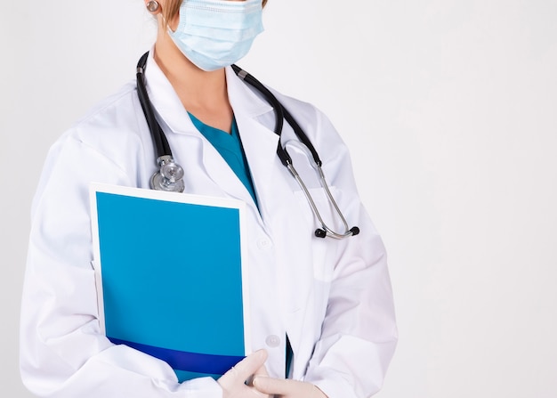 Female doctor with a folder white wall