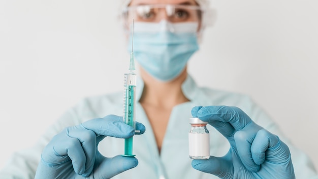 Photo female doctor with gloves holding vaccine and syringe