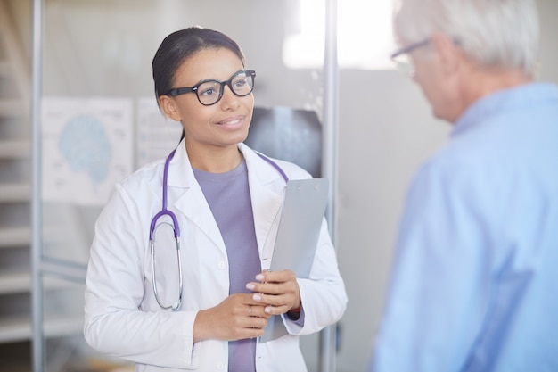 Female doctor with senior patient at hospital