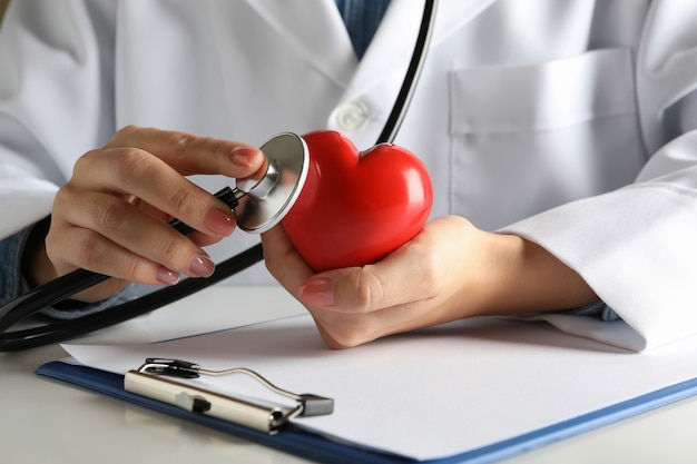 Female doctor with stethoscope checking heart beat