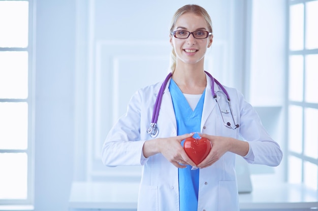 Female doctor with the stethoscope holding heart