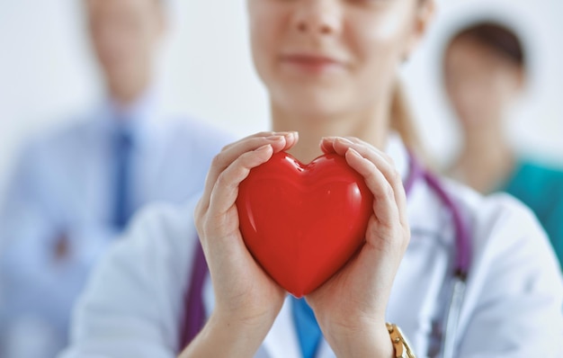 Photo female doctor with stethoscope holding heart .