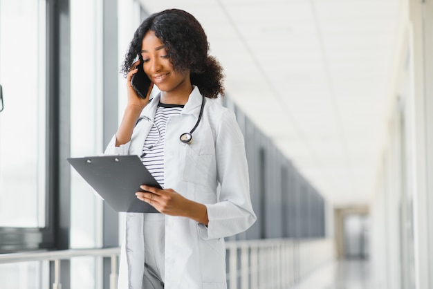 Female doctor with stethoscope on hospital corridor holding clipboard with an operating room at the background ,Healthcare and medical concept,selective focus.