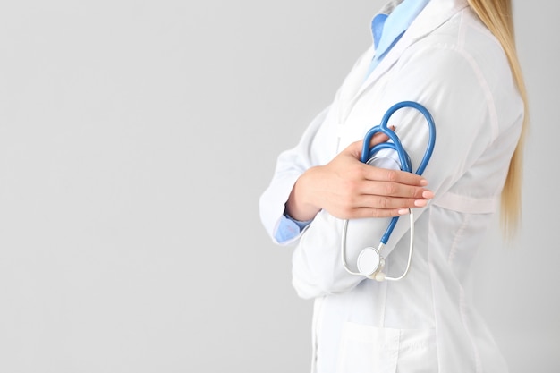 Female doctor with stethoscope on light