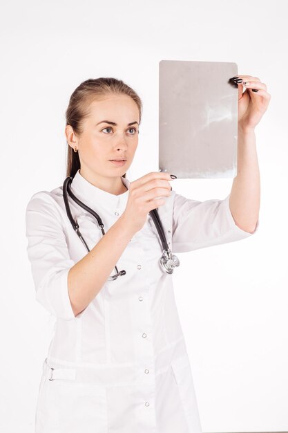 Female doctor with stethoscope looking at xray