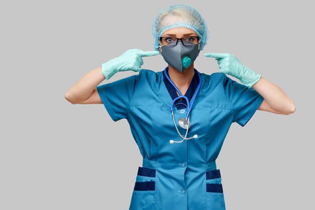 Photo female doctor with stethoscope wearing protective mask and latex gloves over light grey wall