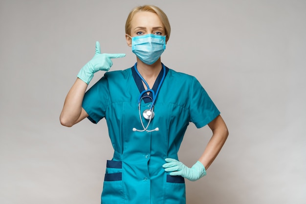 Female doctor with stethoscope wearing protective mask and latex gloves