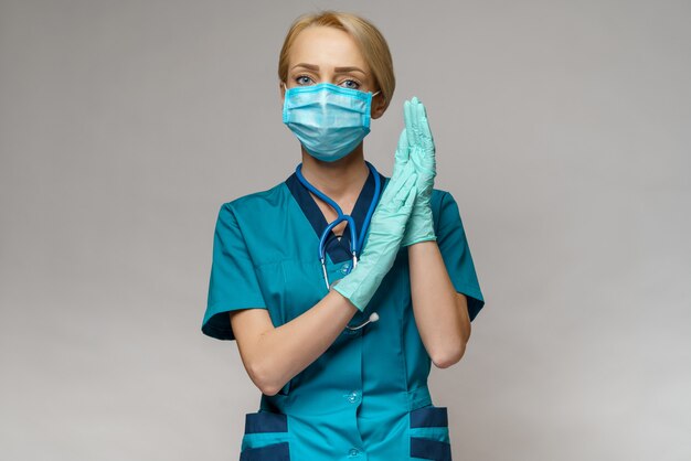 Female doctor with stethoscope wearing protective mask and latex gloves