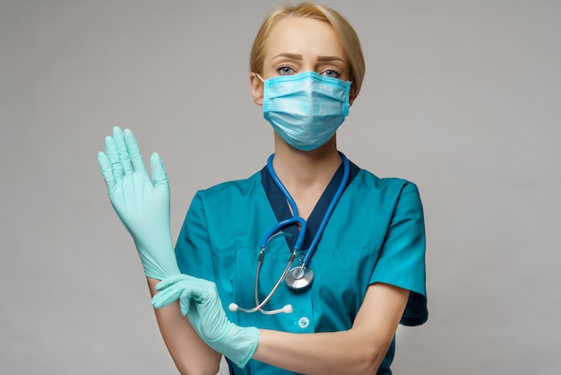 Female doctor with stethoscope wearing protective mask and latex gloves