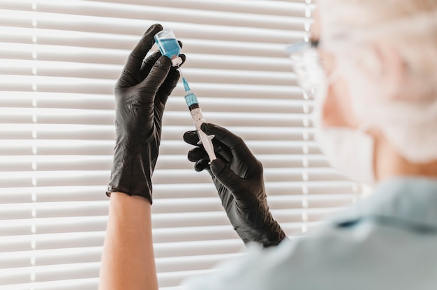 Female doctor with syringe and vaccine