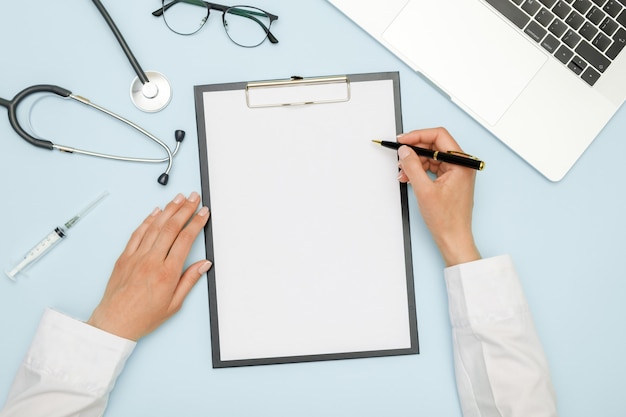 Female doctor working at workplace with laptop