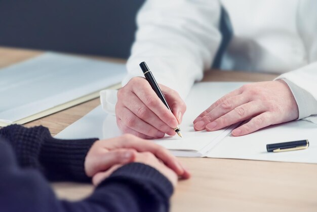 Female doctor writing notes during patients medical exam