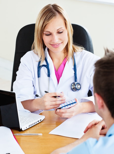 Female doctor writing a prescription to her patient during an appointment