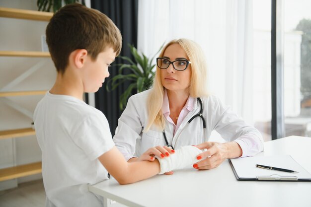 Female doctor and young boy with a broken arm