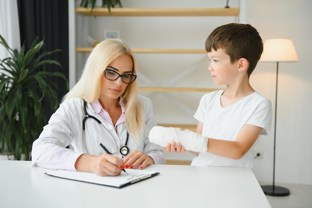 Female doctor and young boy with a broken arm