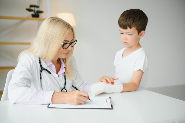 Female doctor and young boy with a broken arm