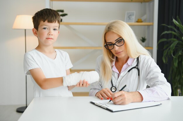 Female doctor and young boy with a broken arm