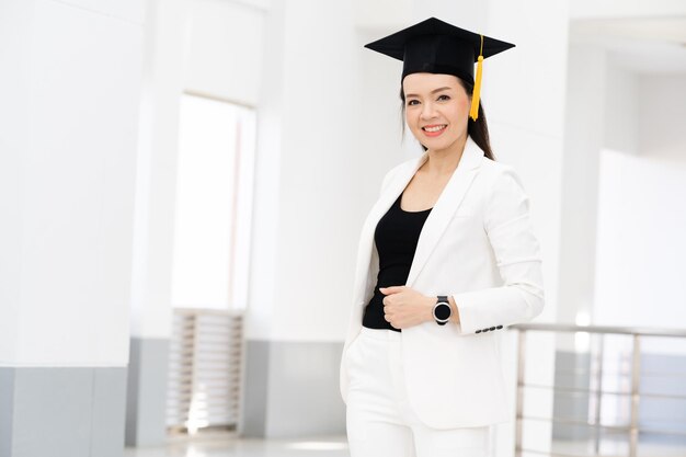 Female doctoral graduates wearing yellow tassel black\
graduation caps are at the university.