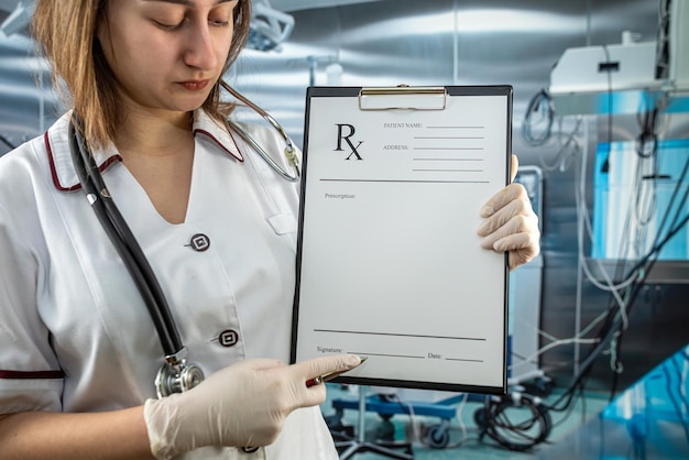 수술실에 제복을 입은 여성 의사는 rx Medical 개념 분석을 위해 환자 데이터를 기록합니다.