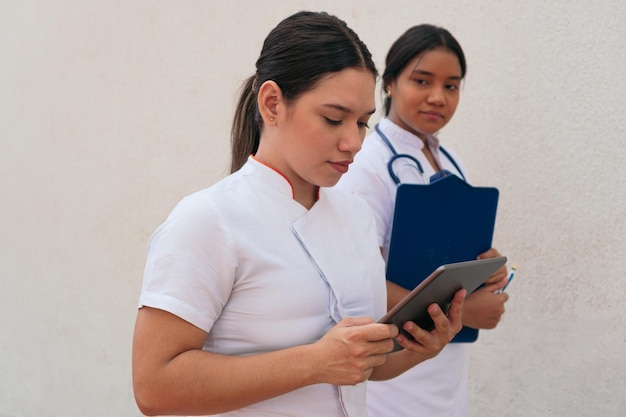 Female doctors using digital tablet in hospital corridor