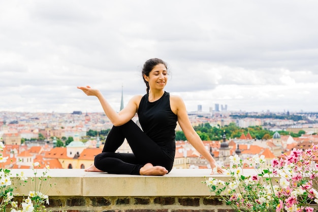 Female does yoga in the background of the city of Prague