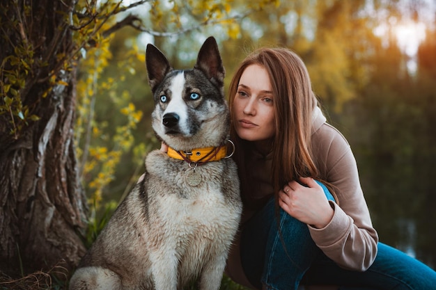 Female dog walker with a pet walking in nature by the\
river