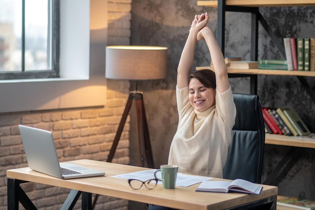 Female doing an armstretching exercise at the writing table