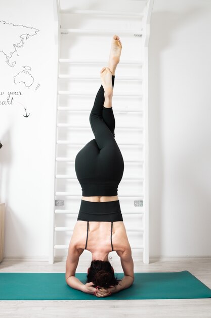 Femmina che fa yoga nella sua casa