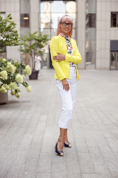 Female dressed in fashion standing on city street