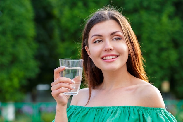 Женщина пьет из стакана воды. Концепция здравоохранения фото