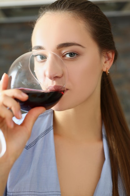 Female drinking red wine from glass and enjoying tasty drink