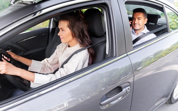 female driver driving car with male passenger
