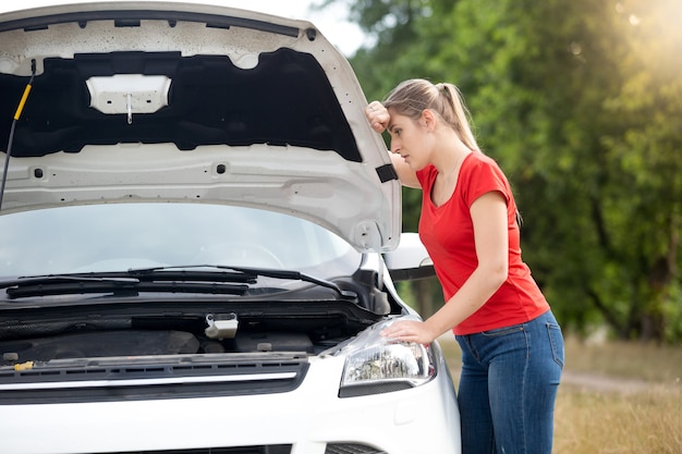 Female driver upset because of the broken car at countryside