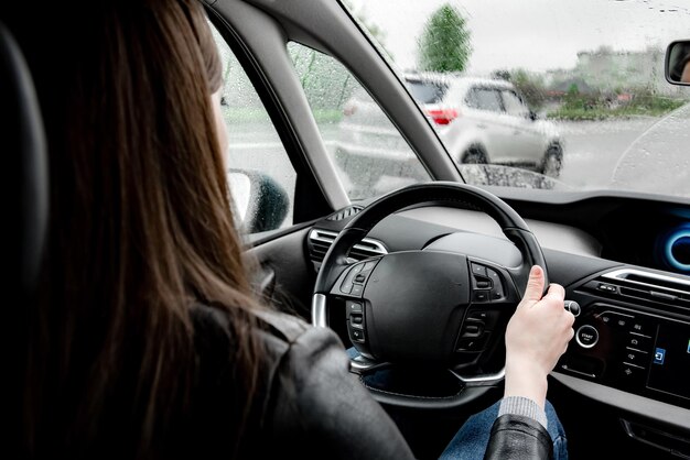 Female driving a car in rainy weather.