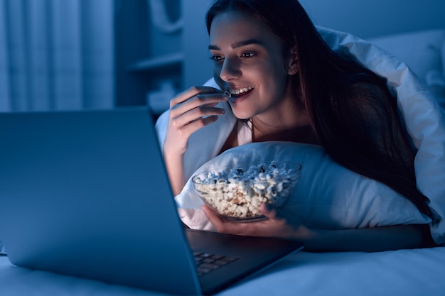 Photo female eating popcorn and watching film