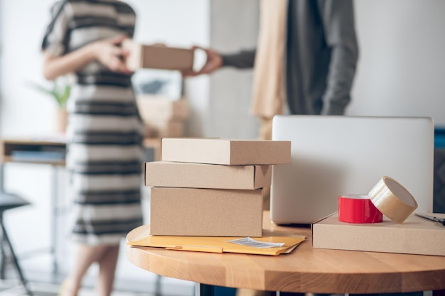 Female employee handing over a package to a deliveryman