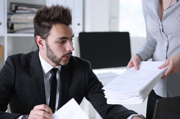 Female employee show pack of documents to manager