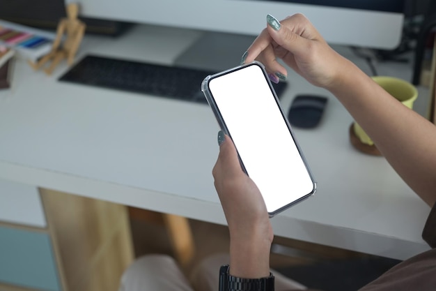 Female employee sitting at her office desk and using mobile phone