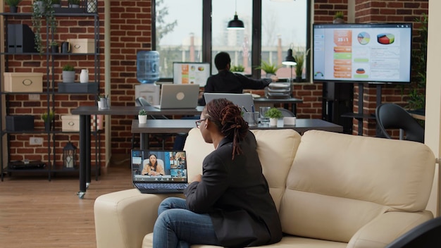 Female employee using remote videocall conference on laptop to
talk to group of people about company growth. office worker
attending online teleconference business meeting on internet.