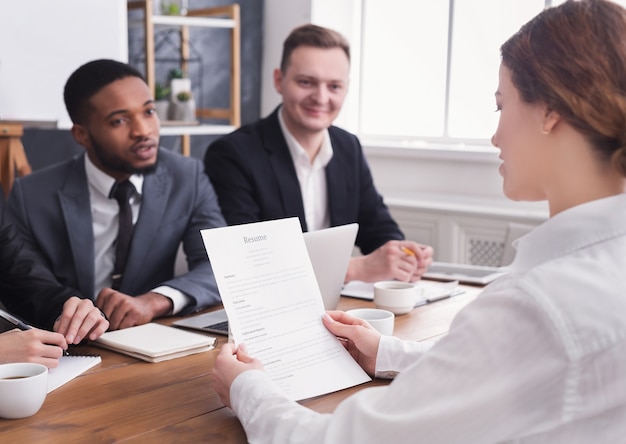 Female employer holding applicant resume during office interview