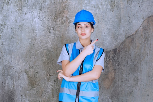 Female engineer in blue helmet showing something above