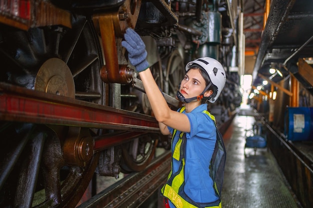 Female engineer checking equipment in factory for repair