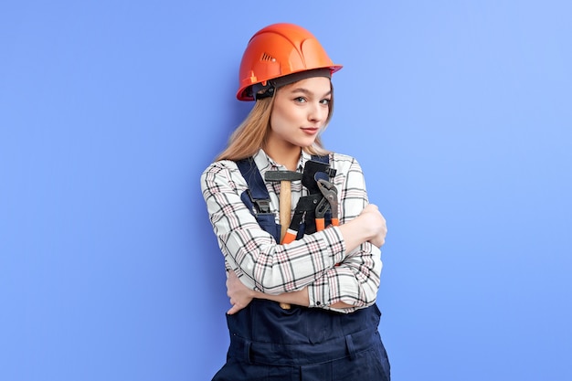 Female engineer constructor hold tools for household in hands and looking at camera