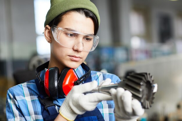 Female engineer examining milling machine tool