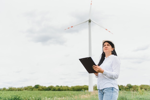 Female engineer holding documents at wind farm