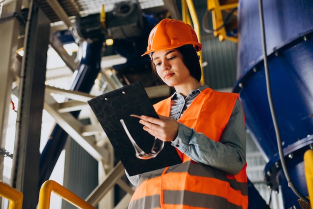 Female engineer reading documents at a factory