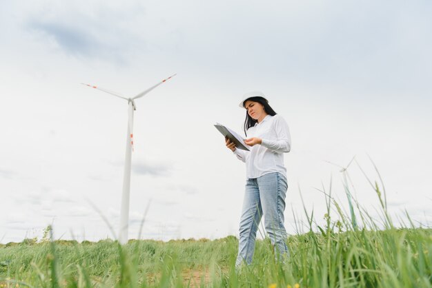 Female engineer with hard hat at the wind turbine farm