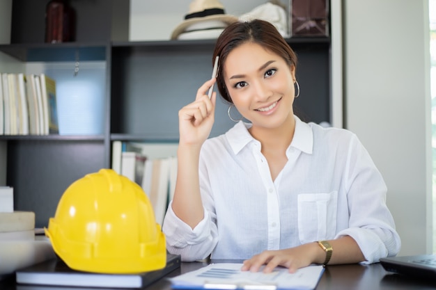 Женщины-инженеры думают создать новые рабочие места и улыбаются и работают счастливыми
